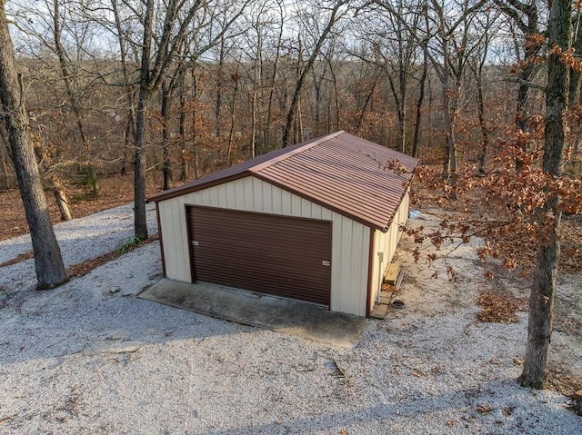 detached garage featuring a view of trees