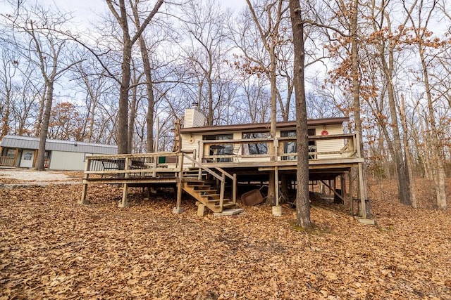 rear view of house with stairway, a chimney, and a wooden deck