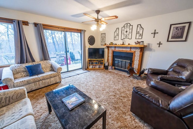 carpeted living room with ceiling fan and a tile fireplace