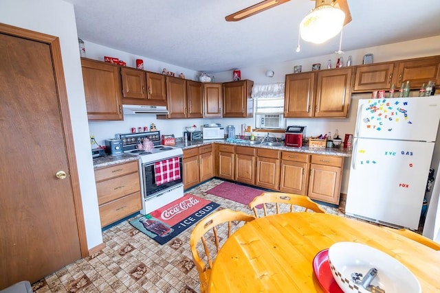 kitchen featuring white appliances, range hood, brown cabinetry, and light countertops