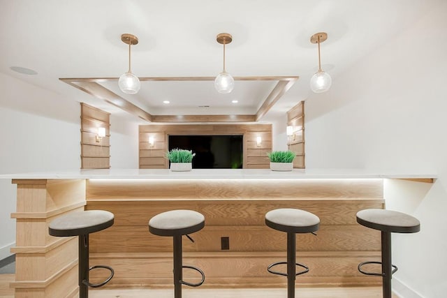 bar featuring a raised ceiling and pendant lighting