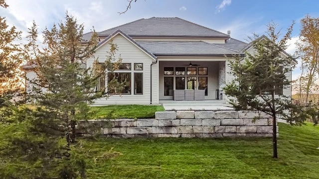 rear view of property with a porch and a yard