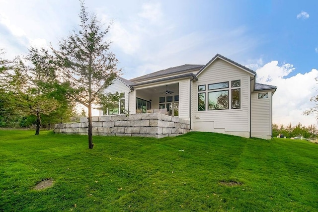 back of house featuring ceiling fan and a lawn