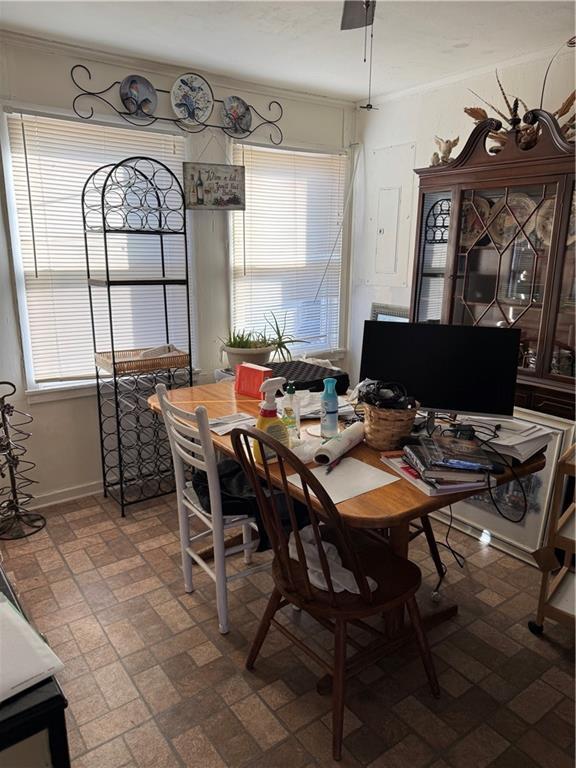 dining room featuring brick floor, baseboards, and crown molding