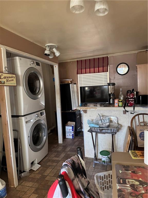 laundry room featuring laundry area and stacked washer / drying machine