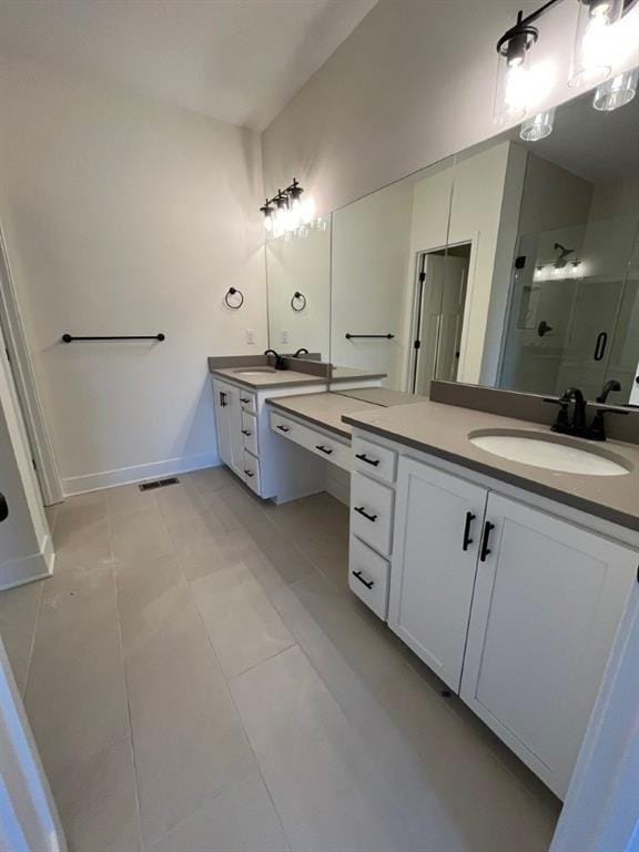 bathroom with a stall shower, two vanities, a sink, and visible vents