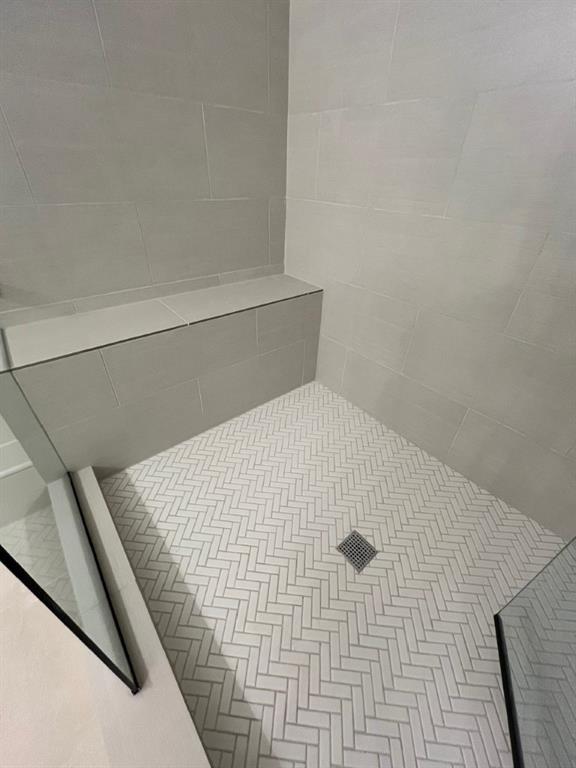 interior details featuring tiled shower