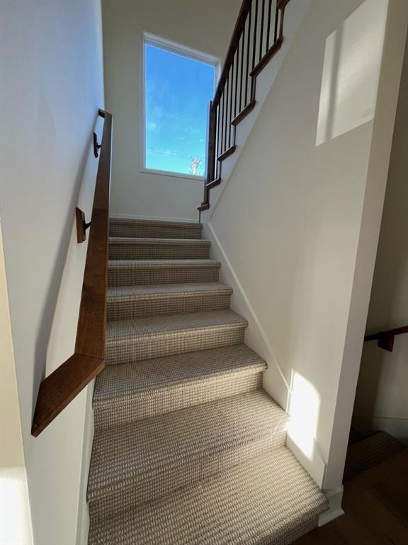 stairway featuring wood finished floors and baseboards