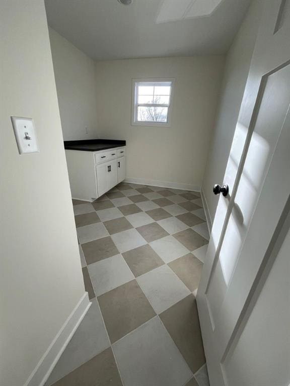 laundry room featuring baseboards and light floors