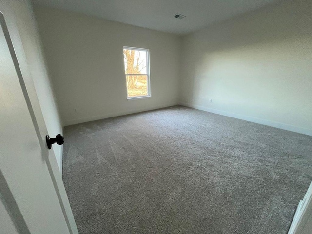 carpeted empty room featuring visible vents and baseboards