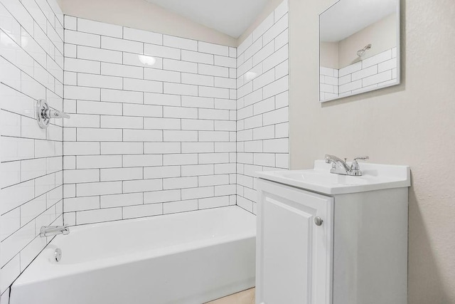 bathroom featuring washtub / shower combination, lofted ceiling, and vanity