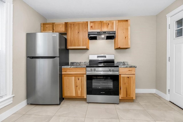 kitchen with light tile patterned floors, appliances with stainless steel finishes, baseboards, and under cabinet range hood