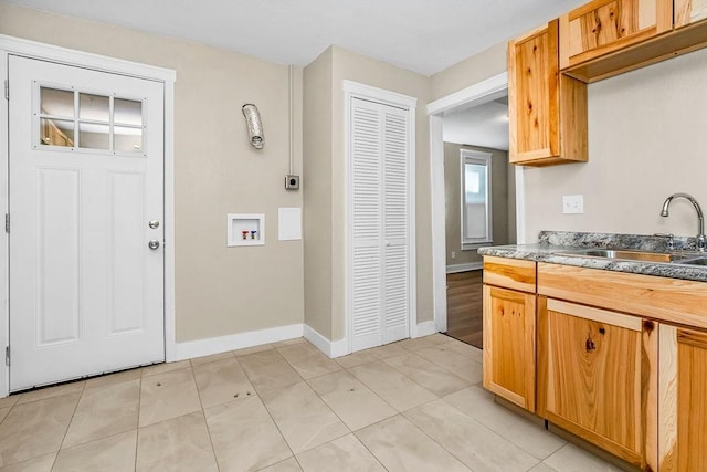 kitchen with light tile patterned flooring, a sink, and baseboards