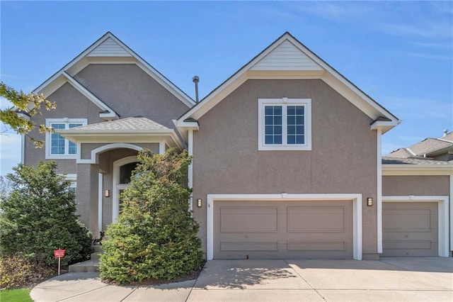 traditional home featuring concrete driveway, stucco siding, and a garage