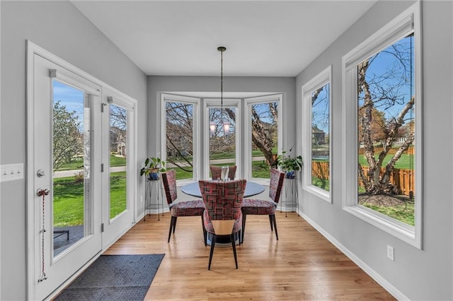 sunroom / solarium featuring french doors, healthy amount of natural light, and wood finished floors