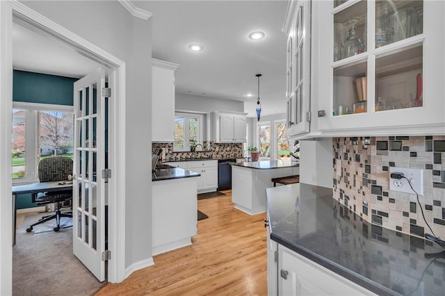 kitchen featuring black dishwasher, dark countertops, tasteful backsplash, white cabinets, and a desk