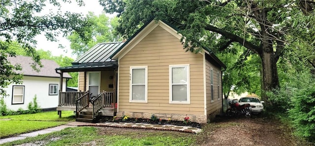 408 W Peoria St, Paola, KS 66071 - bungalow with a standing seam roof, metal roof, a front yard, and dirt driveway