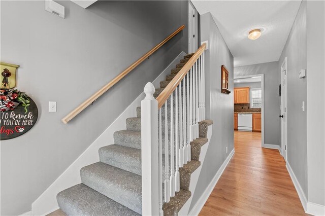 stairway featuring wood finished floors and baseboards