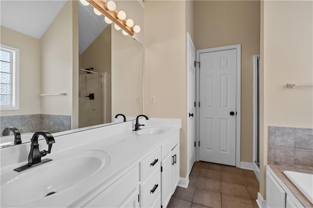 bathroom featuring tile patterned floors, a stall shower, and a sink