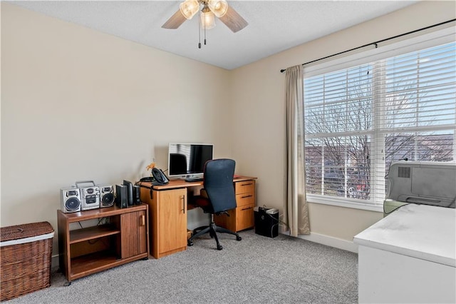 office space with plenty of natural light, light colored carpet, baseboards, and ceiling fan