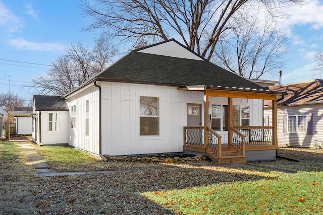 rear view of house featuring a shingled roof and board and batten siding