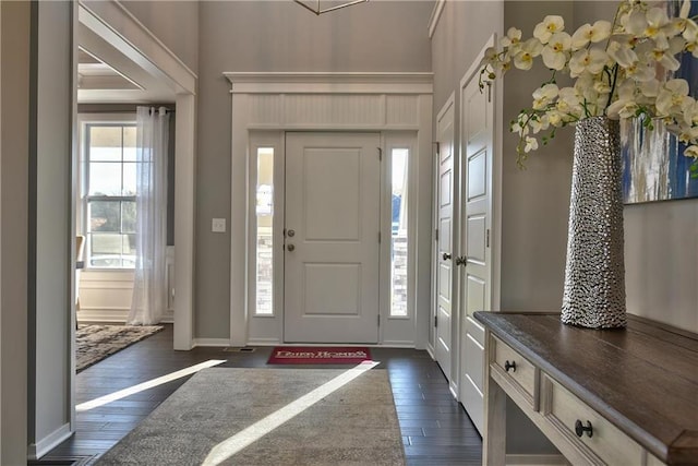 foyer entrance featuring a healthy amount of sunlight, baseboards, and dark wood-style flooring