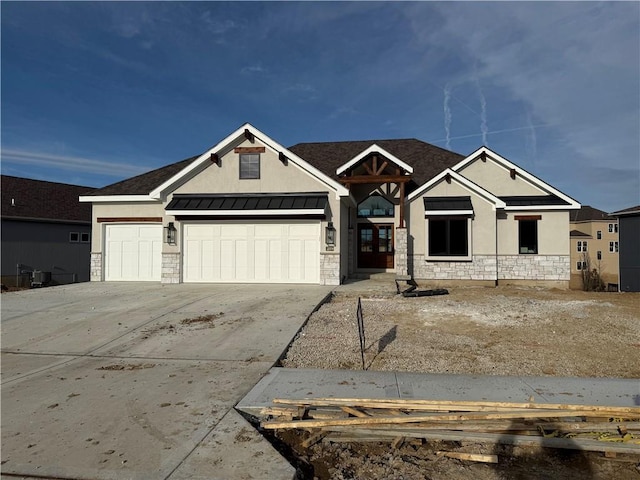 view of front facade with concrete driveway, a standing seam roof, metal roof, a garage, and stone siding