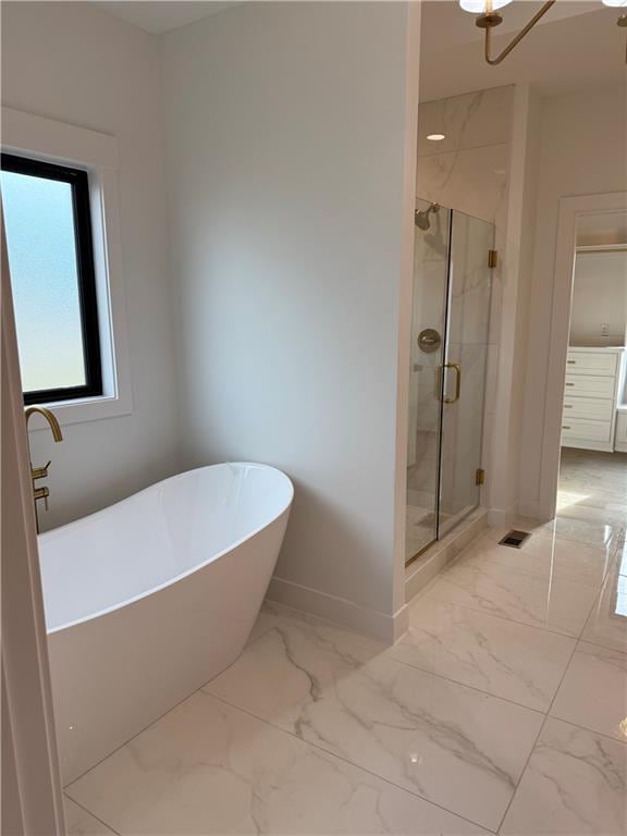 bathroom with a freestanding tub, visible vents, baseboards, marble finish floor, and a shower stall