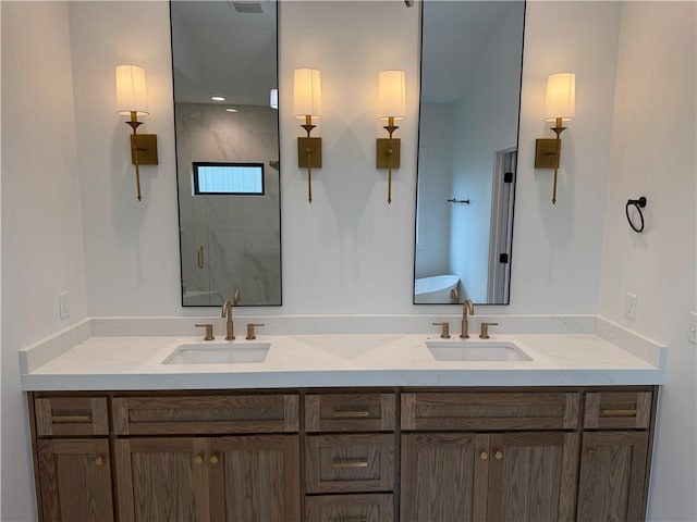 full bath with a stall shower, a sink, and double vanity