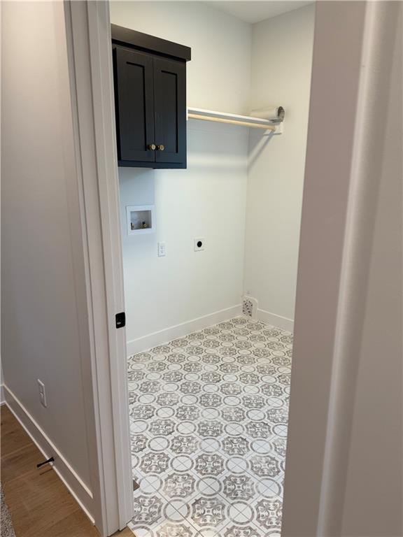 laundry area featuring washer hookup, cabinet space, electric dryer hookup, and baseboards