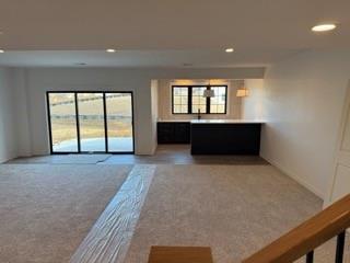 unfurnished living room with recessed lighting and light colored carpet