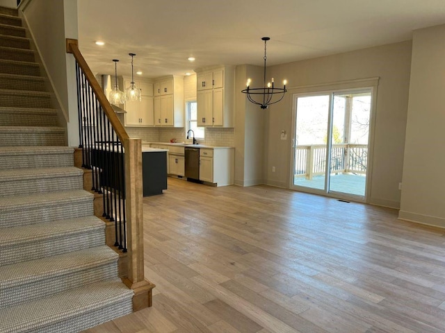 stairway featuring recessed lighting, wood finished floors, baseboards, and an inviting chandelier