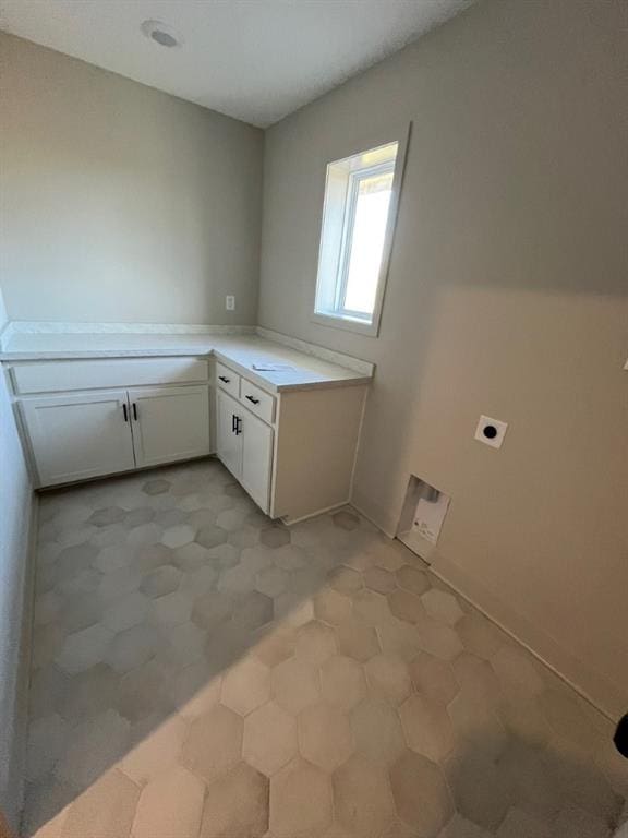 clothes washing area with cabinet space and hookup for an electric dryer