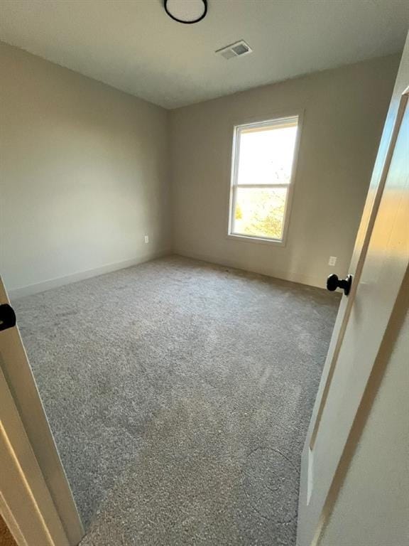 empty room with visible vents and carpet flooring