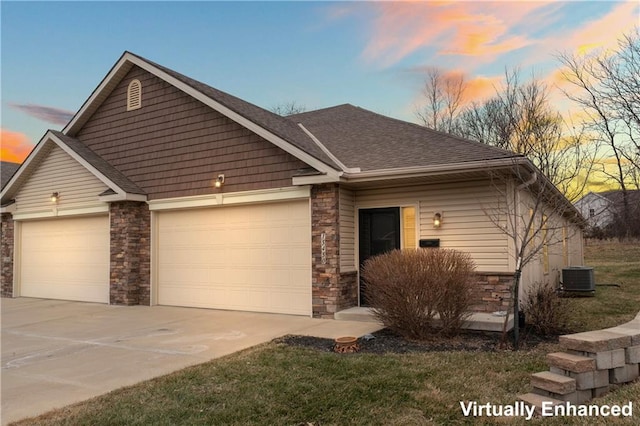 view of front of property with roof with shingles, an attached garage, central AC, stone siding, and driveway