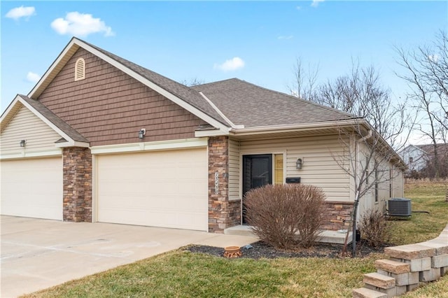 view of front of home featuring central AC unit, a garage, stone siding, concrete driveway, and roof with shingles