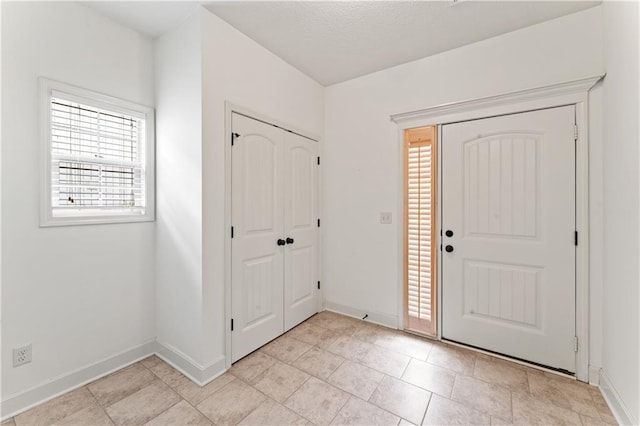 foyer featuring baseboards