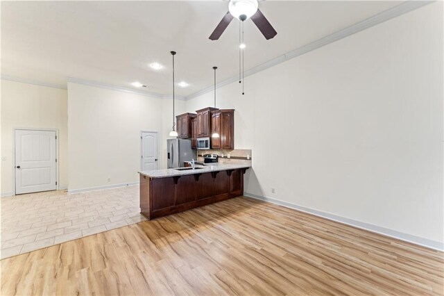 kitchen with a breakfast bar area, decorative backsplash, appliances with stainless steel finishes, ornamental molding, and a peninsula