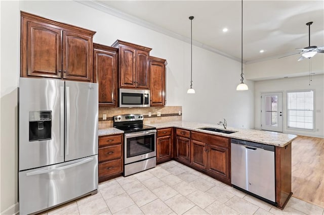 kitchen with stainless steel appliances, a peninsula, a sink, ornamental molding, and backsplash