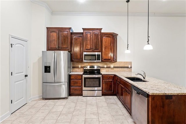 kitchen featuring ornamental molding, a peninsula, appliances with stainless steel finishes, and a sink