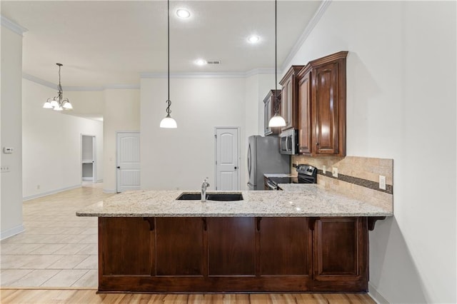 kitchen featuring stainless steel appliances, a sink, a peninsula, and light stone countertops