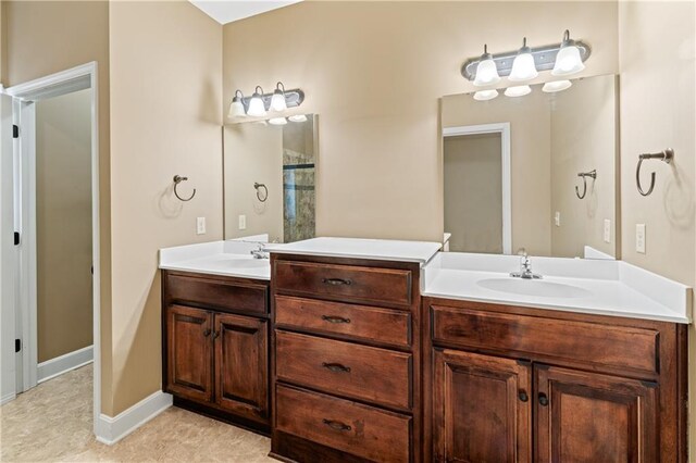 bathroom featuring double vanity, baseboards, and a sink