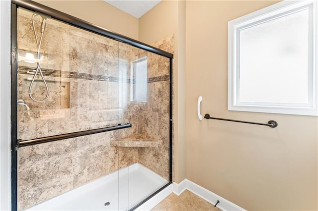 full bathroom featuring a shower stall and baseboards