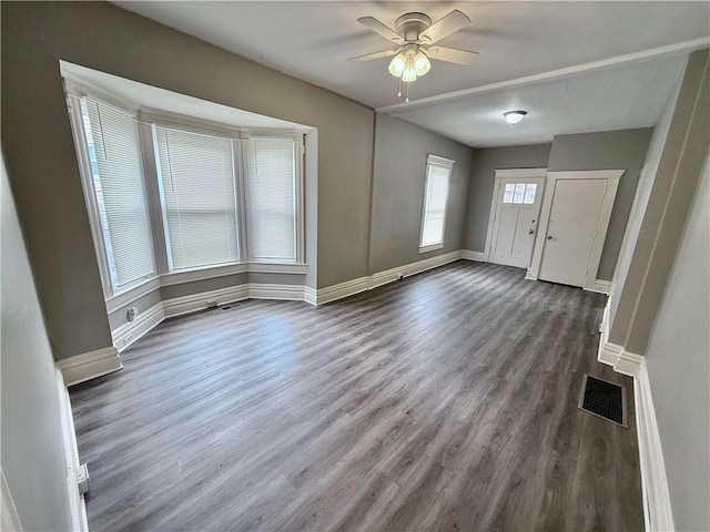 foyer with dark wood-style floors, visible vents, baseboards, and a ceiling fan