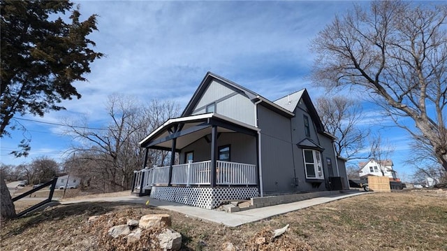 view of side of home featuring covered porch