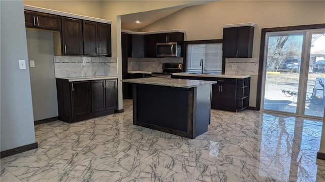 kitchen with stainless steel appliances, a kitchen island, a sink, vaulted ceiling, and decorative backsplash