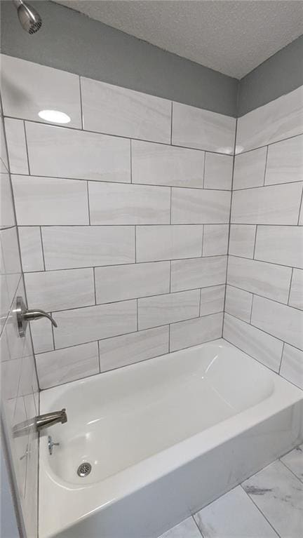 bathroom with shower / bath combination, marble finish floor, and a textured ceiling