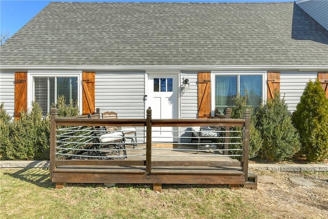 rear view of property with a deck and a shingled roof