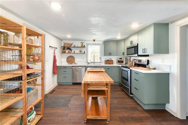 kitchen with stainless steel appliances, light countertops, green cabinets, and open shelves