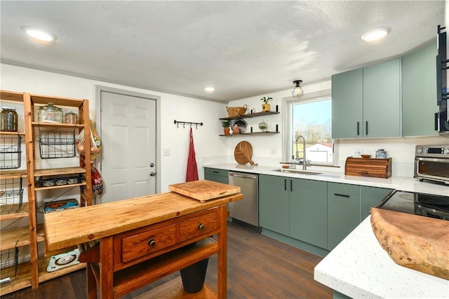 kitchen with dishwasher, dark wood-style floors, light countertops, green cabinets, and a sink